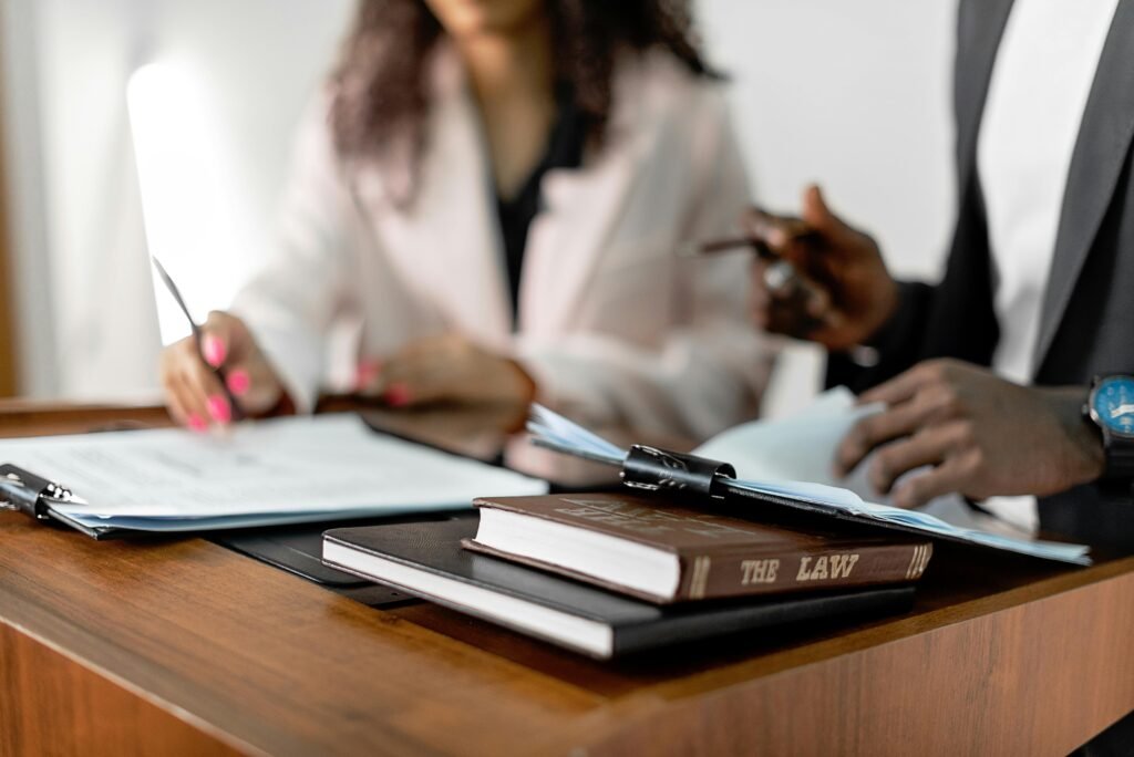pexels-photo-8730785-8730785 Two lawyers reviewing documents with law books on a desk. Professional legal environment.